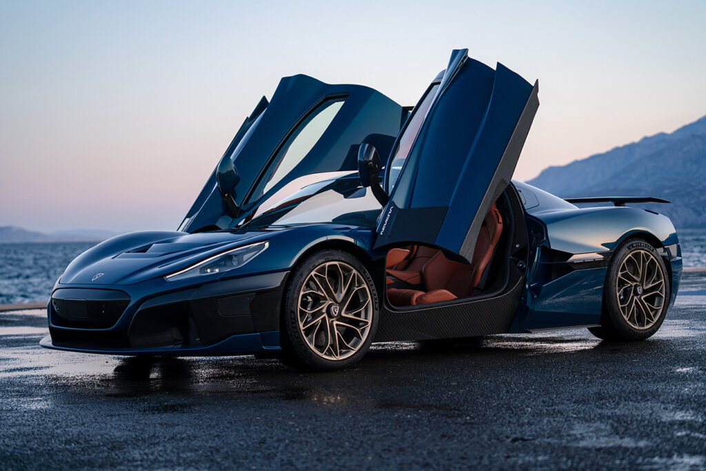 luxury car with open doors on beach in the evening