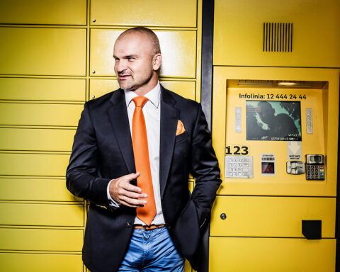 rafał brzoska standing in front of yellow parcel locker