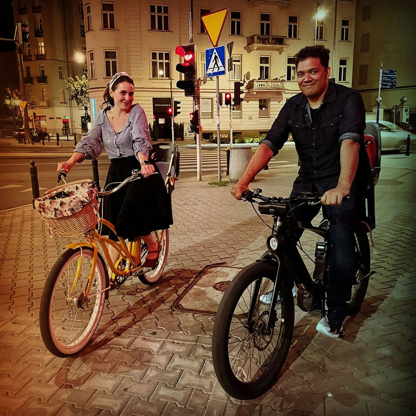 woman and man on a bike in Warsaw Poland at night