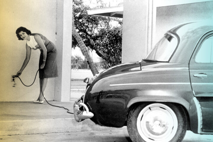 View of a woman charging the vintage electric car