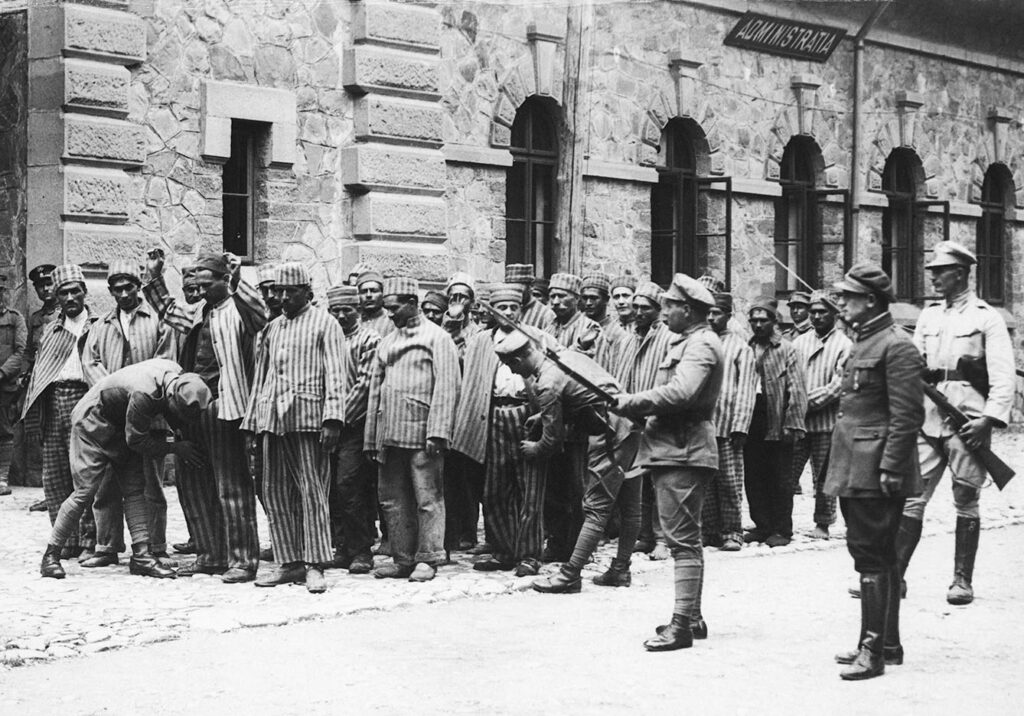 Prisoners returning from work are searched by their guards before entering Doftana Prison in Romania archive photo