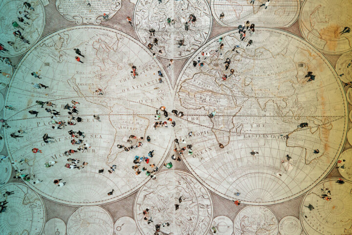 Crowd walking on global map. Composition made with antique map from 1779