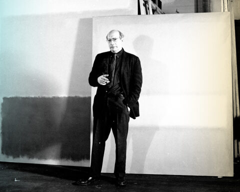 Aritst mark Rothko standing in front of his paintings