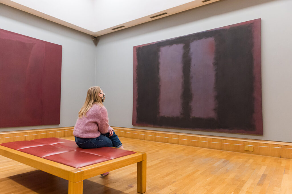 woman in gallery looks at Mark Rothkos The Seagram Murals Black on Maroon