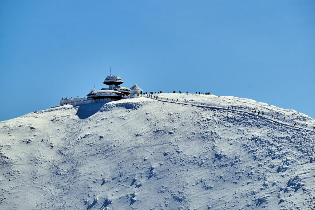 People and tourist hostel on top of Sniezka in the Giant Mountains in Poland view from the distance