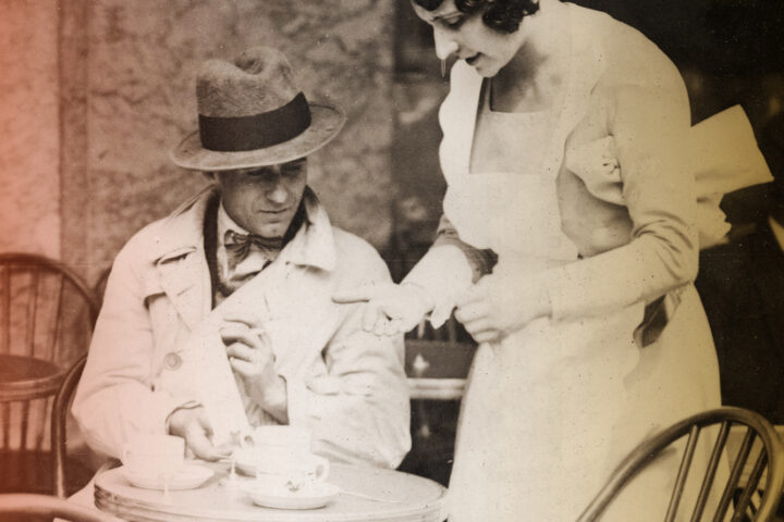 A waitress at a cafe terrace on archive photo from 1930 waiting for tip