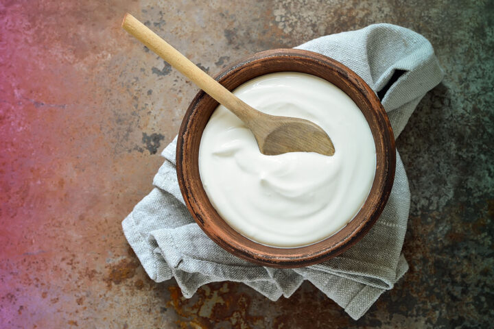 Homemade yogurt in a bowl with wooden spoon