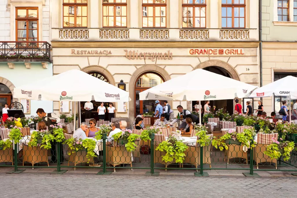 People enjoying the lunch break in an outdoor restaurant Wierzynek located on the Cracows Market Square
