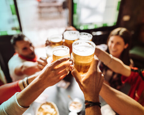 People talking toasting in a pub with the beers stock photo
