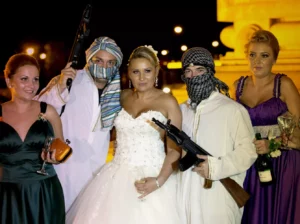 Romanian bride poses with mock kidnappers holding a toy weapons at the Triumph Arch in Bucharest Romania