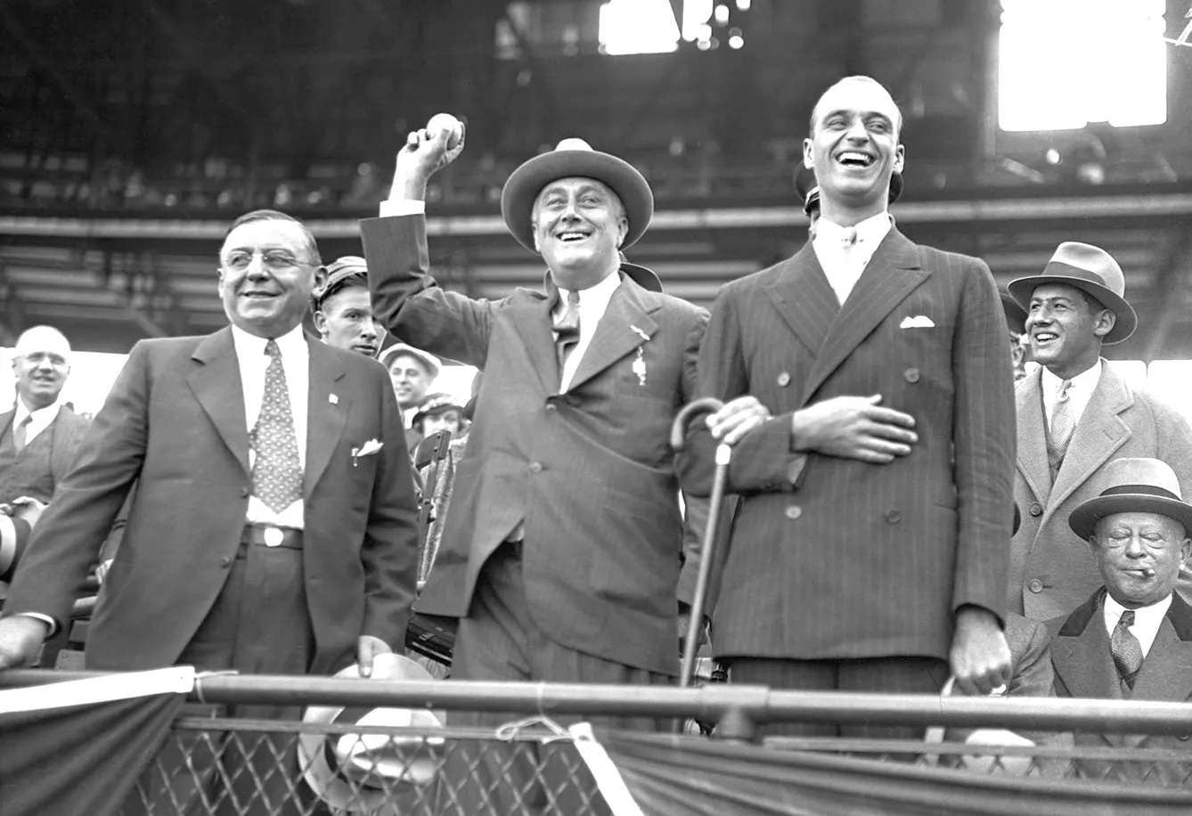 New York Governor and presidential candidate Franklin Roosevelt throws out a baseball at the last game of the 1932 World Series between the Chicago Cubs and the New York Yankees. To the right is his son James. To the left is Chicago Mayor Anton Cermak.
