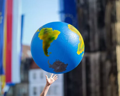 student reaches for an inflated globe