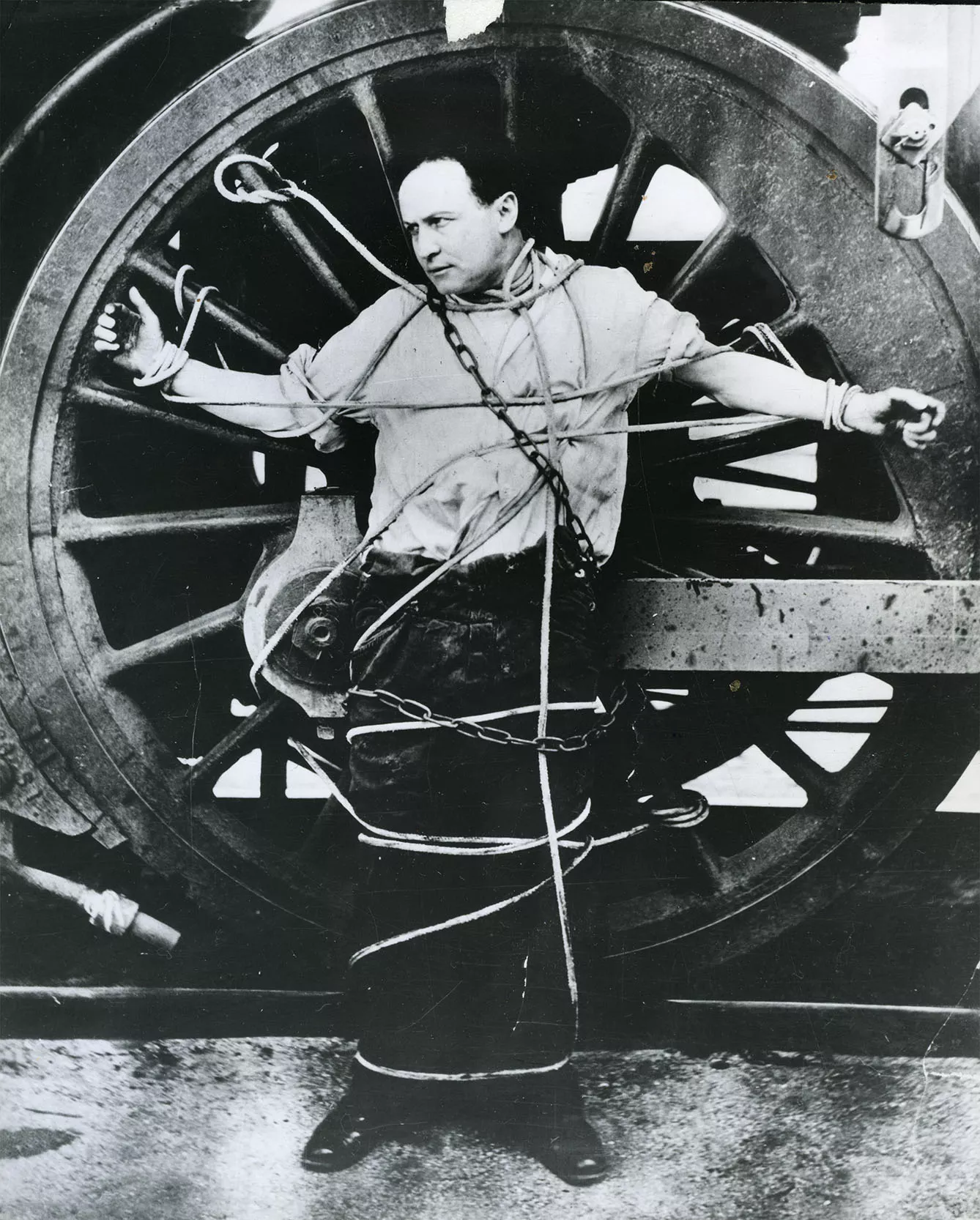 Harry Houdini Strapped To A Locomotive Wheel