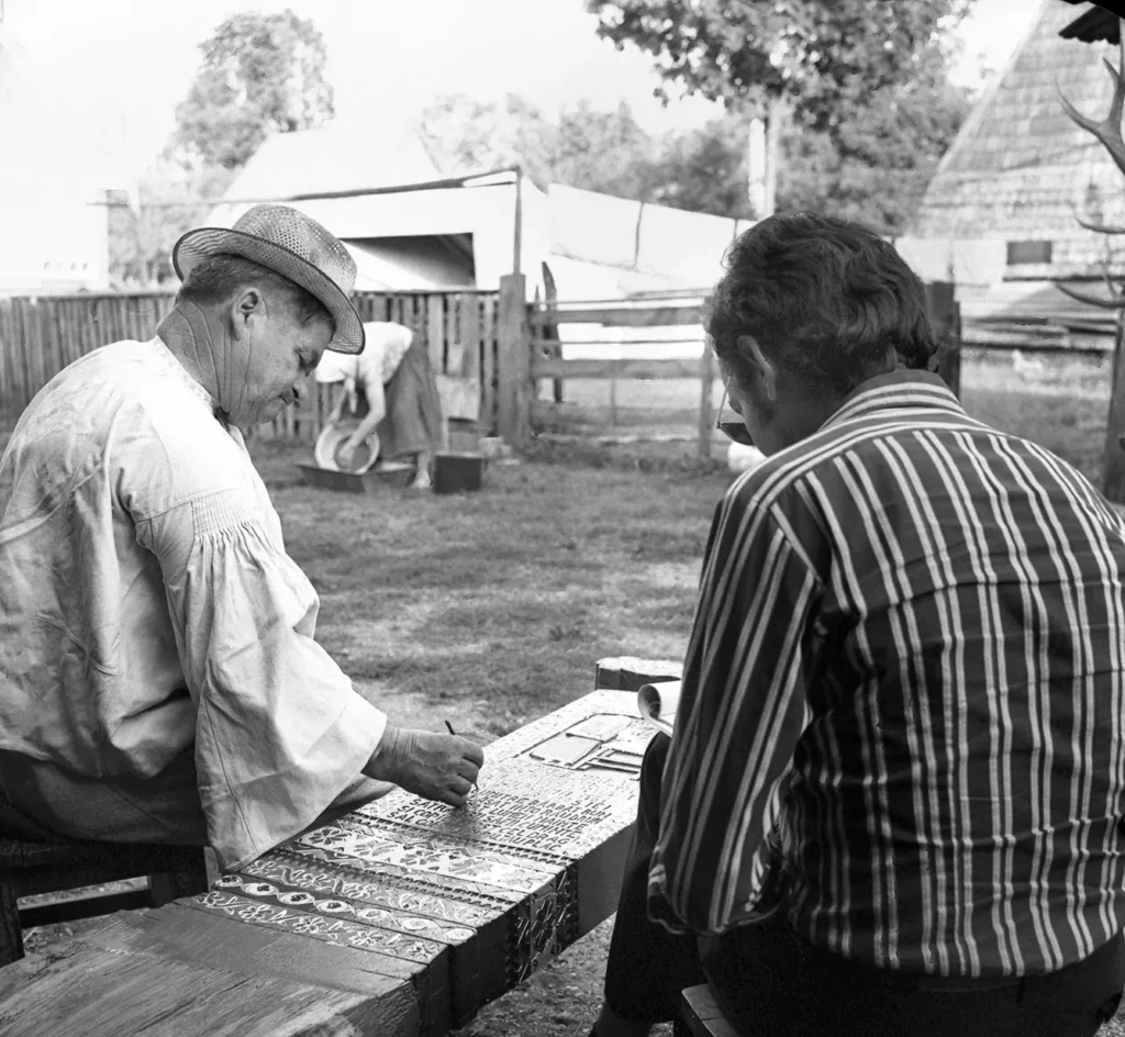 Sapanta, Maramures, approx. 1973. Romanian journalist Elisei Tarta interviewing the famous folk artist Stan Ioan Pătraş, the creator of the well-known "Merry Cemetery".