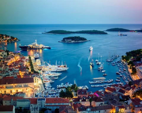 iew of the illuminated old town Hvar and the harbor with Pakleni Islands at dusk