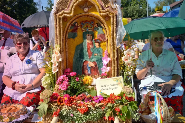 Representatives from Parish Godowa, dressed in traditional folk costumes, seat near their Parish wreaths and loaves during the Holy Mass at the 2015 edition of the annual Harvest Festival in Rzeszow