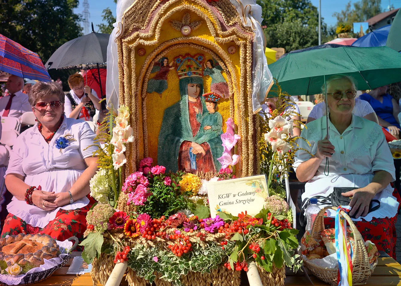 Representatives from Parish Godowa, dressed in traditional folk costumes, seat near their Parish wreaths and loaves during the Holy Mass at the 2015 edition of the annual Harvest Festival in Rzeszow
