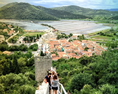 A group of tourists walking down along the the Walls of Ston, towards the ancient town of Ston, Croatia