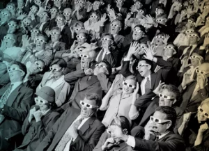 group of spectators sitting in a movie theater wearing 3-D glasses