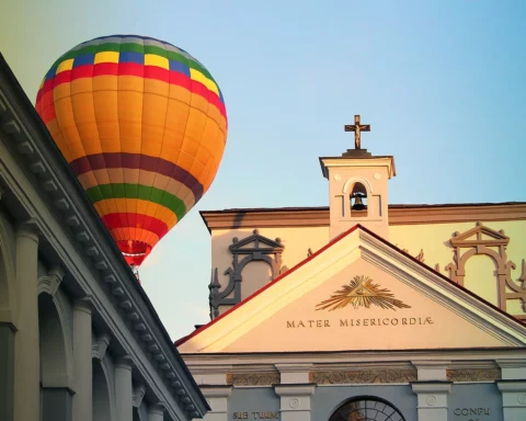 Huge tourism balloon floats very close to a church rooftop, in the city of Vilnius