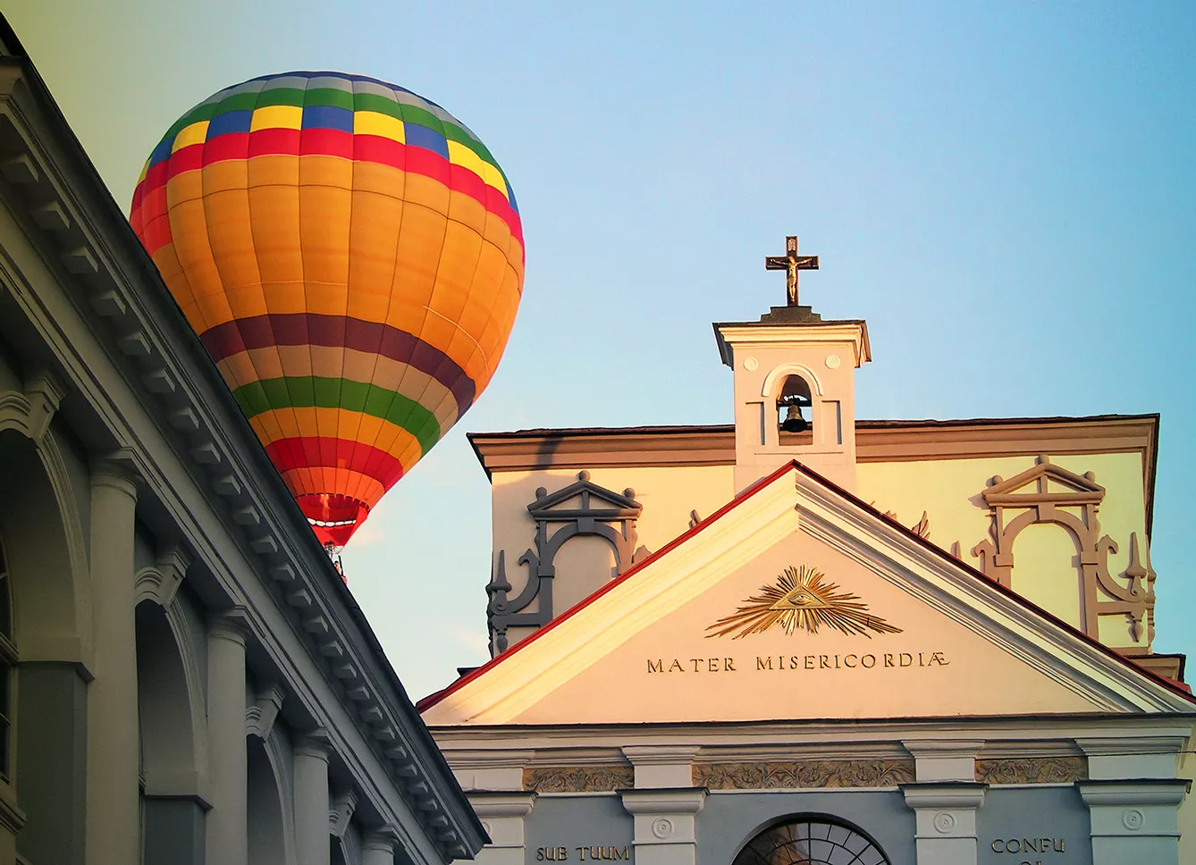 Huge tourism balloon floats very close to a church rooftop, in the city of Vilnius