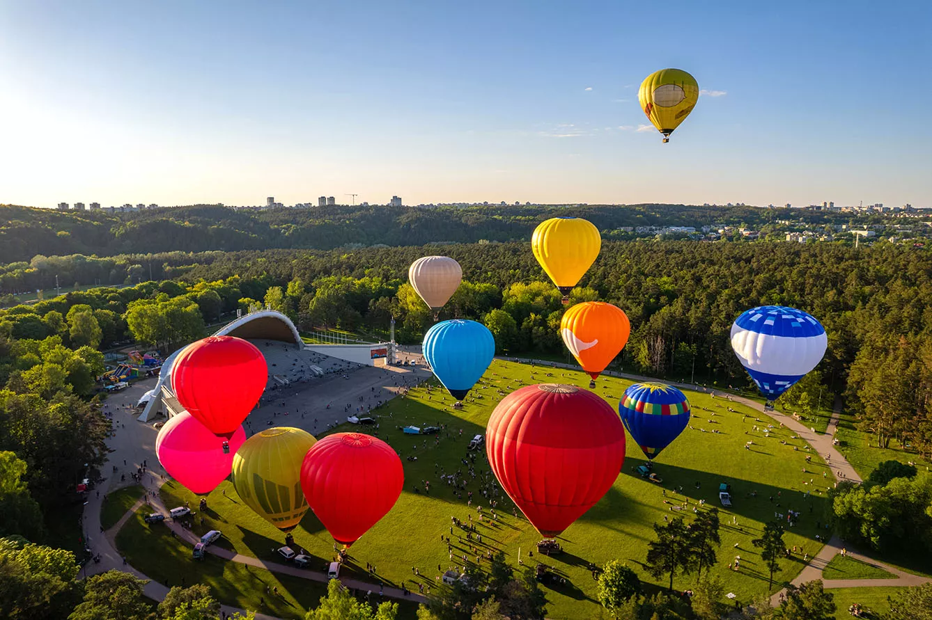 Aerial spring evening view of rising hot air balloons over Vingis Park in Vilnius