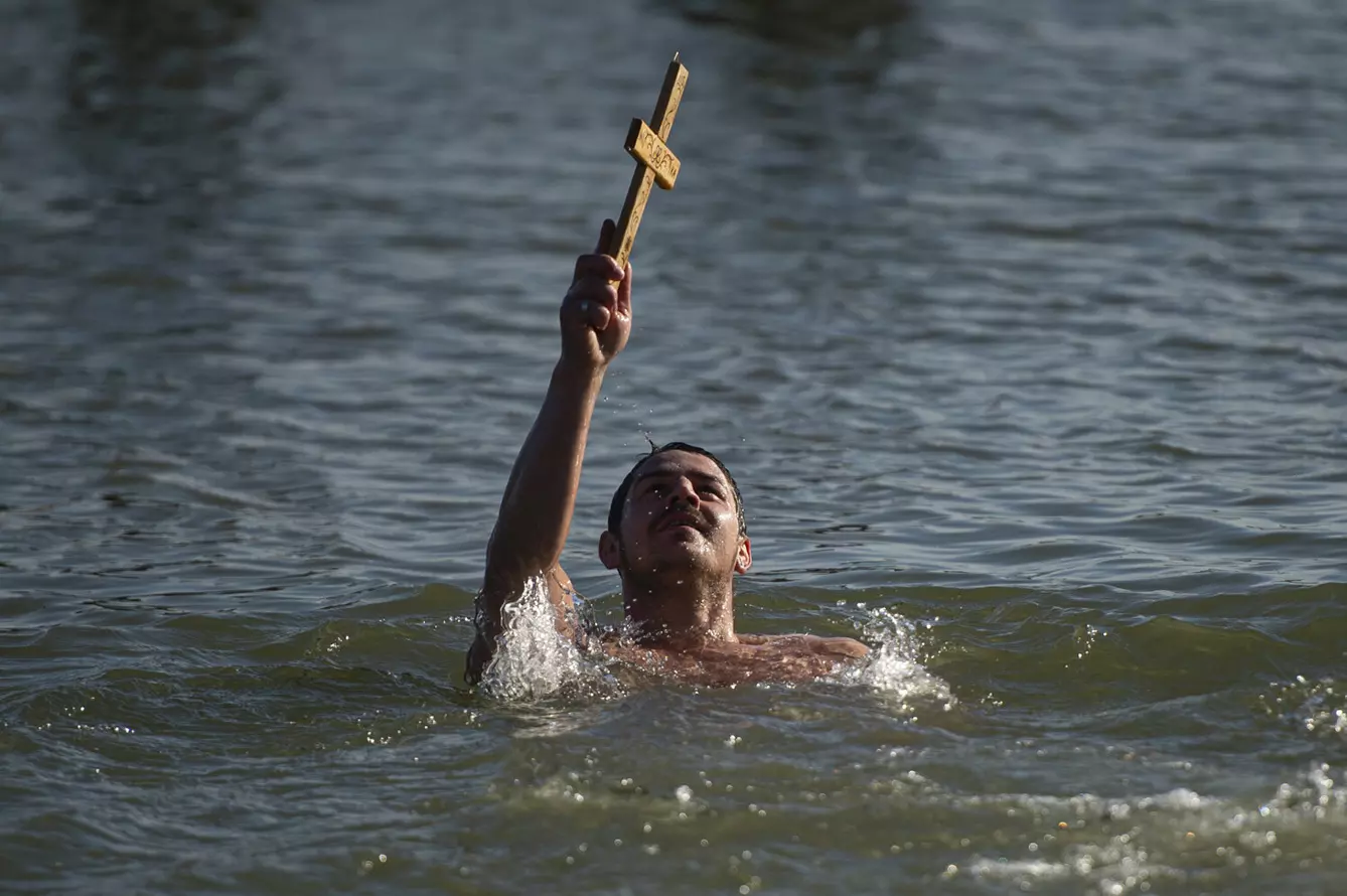 A man shows the wooden cross he retrieved from the Danube river