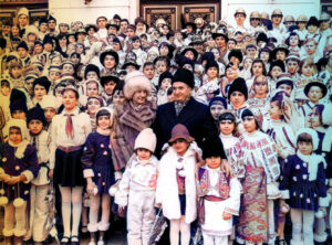 Romanian dictator Nicolae Ceausescu and his wife Elena with a large group of children in national costume