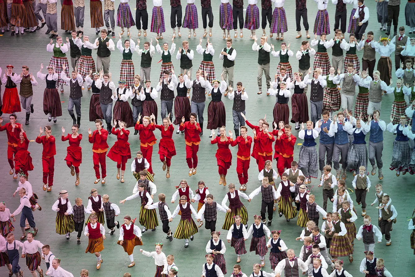 Dancers in traditional costumes perform at the Grand Folk dance concert of Latvian Youth Song and Dance Festival