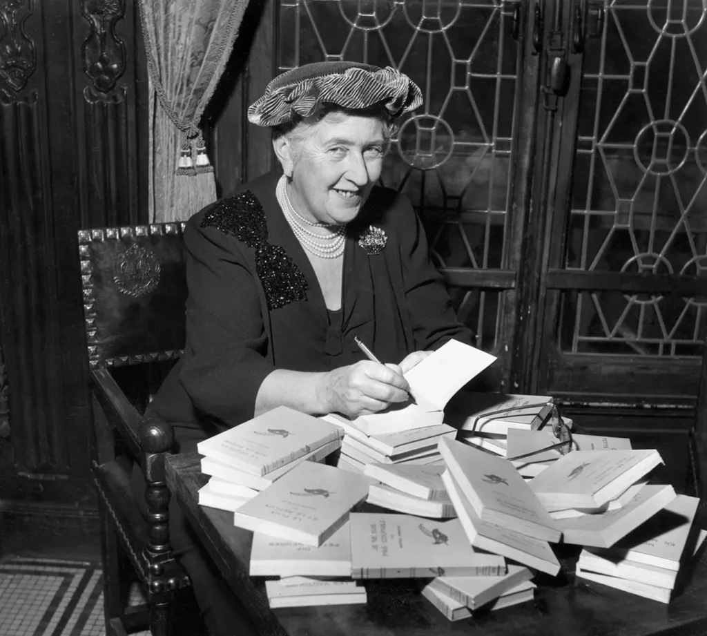 archive photo of british mystery author Agatha Christie autographing her books