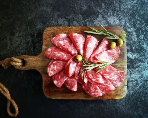 thinly sliced salami on a wooden cuttingboard