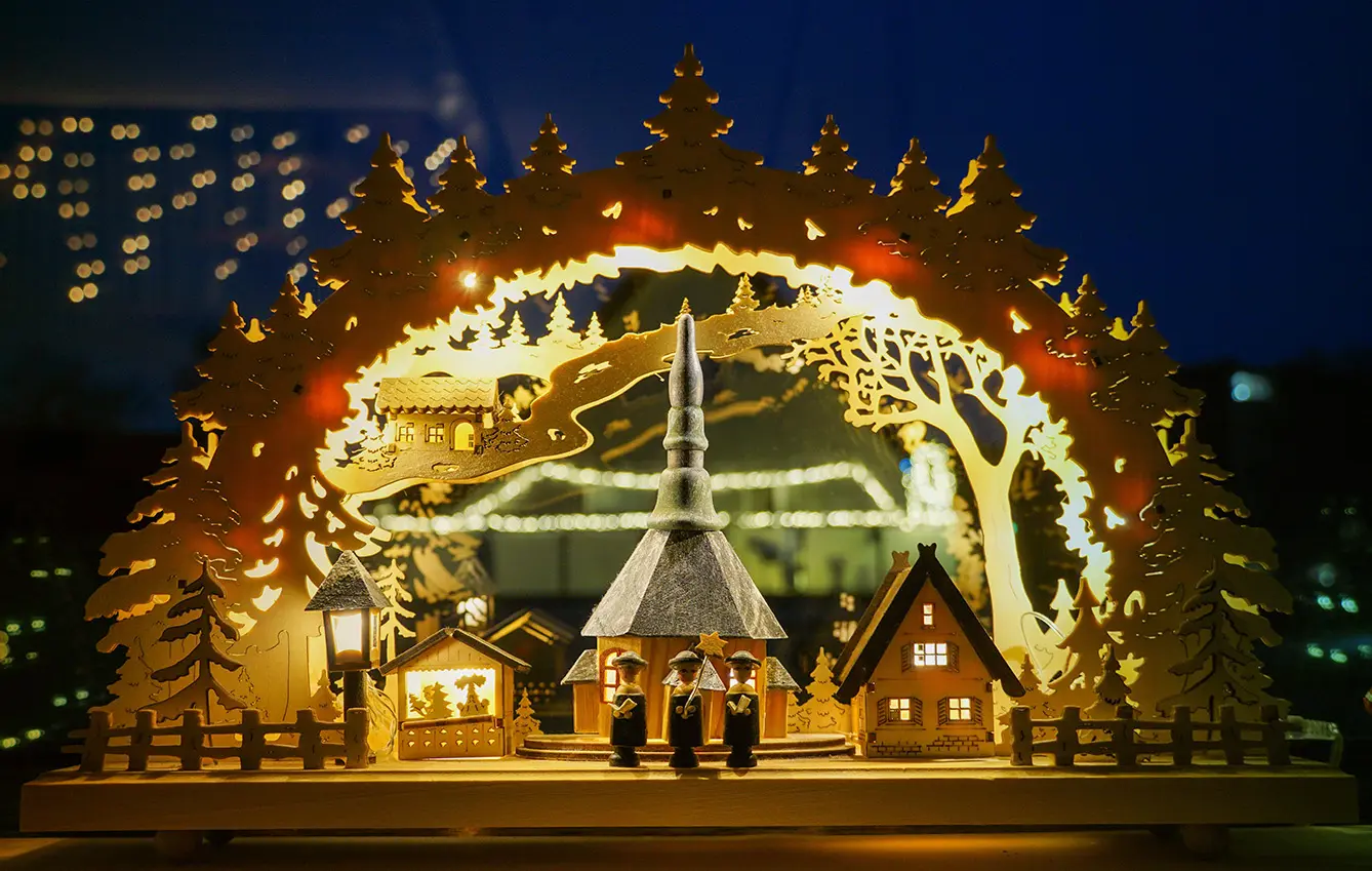 Panoramic shot of a plywood Christmas scene under arc made by wood and lights
