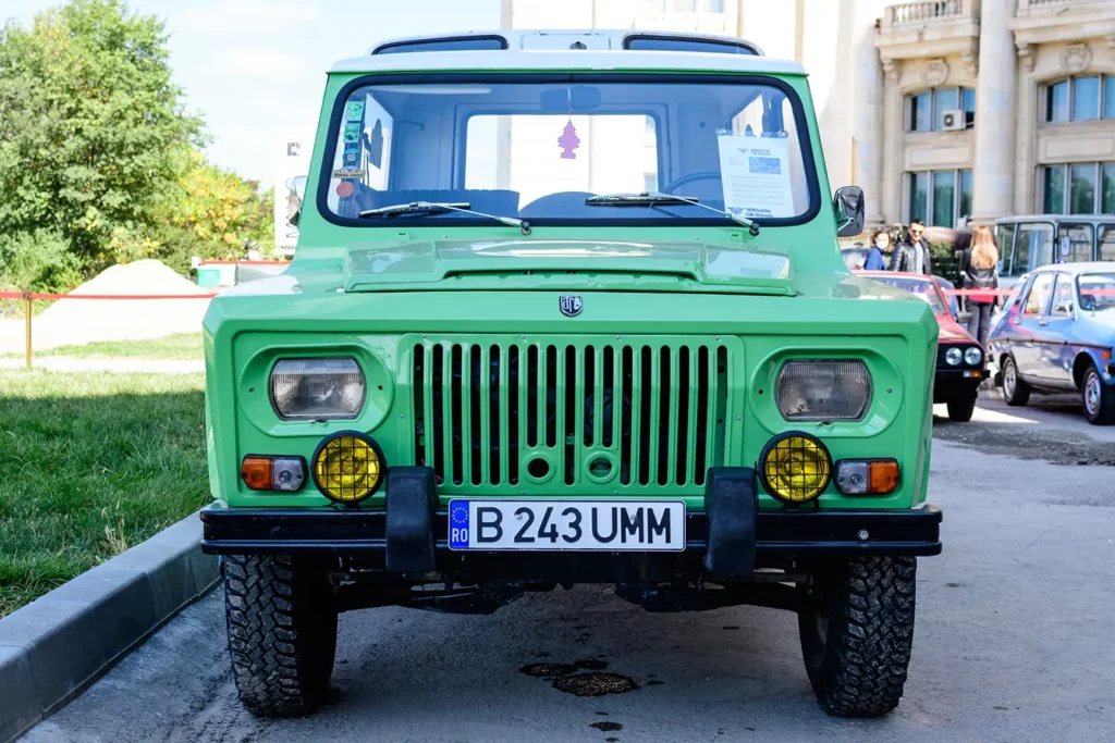 One vivid green Aro 243 vintage car produced in year 1978 and parked in a street of Bucharest at an event for vintage cars collections, in a sunny autumn day