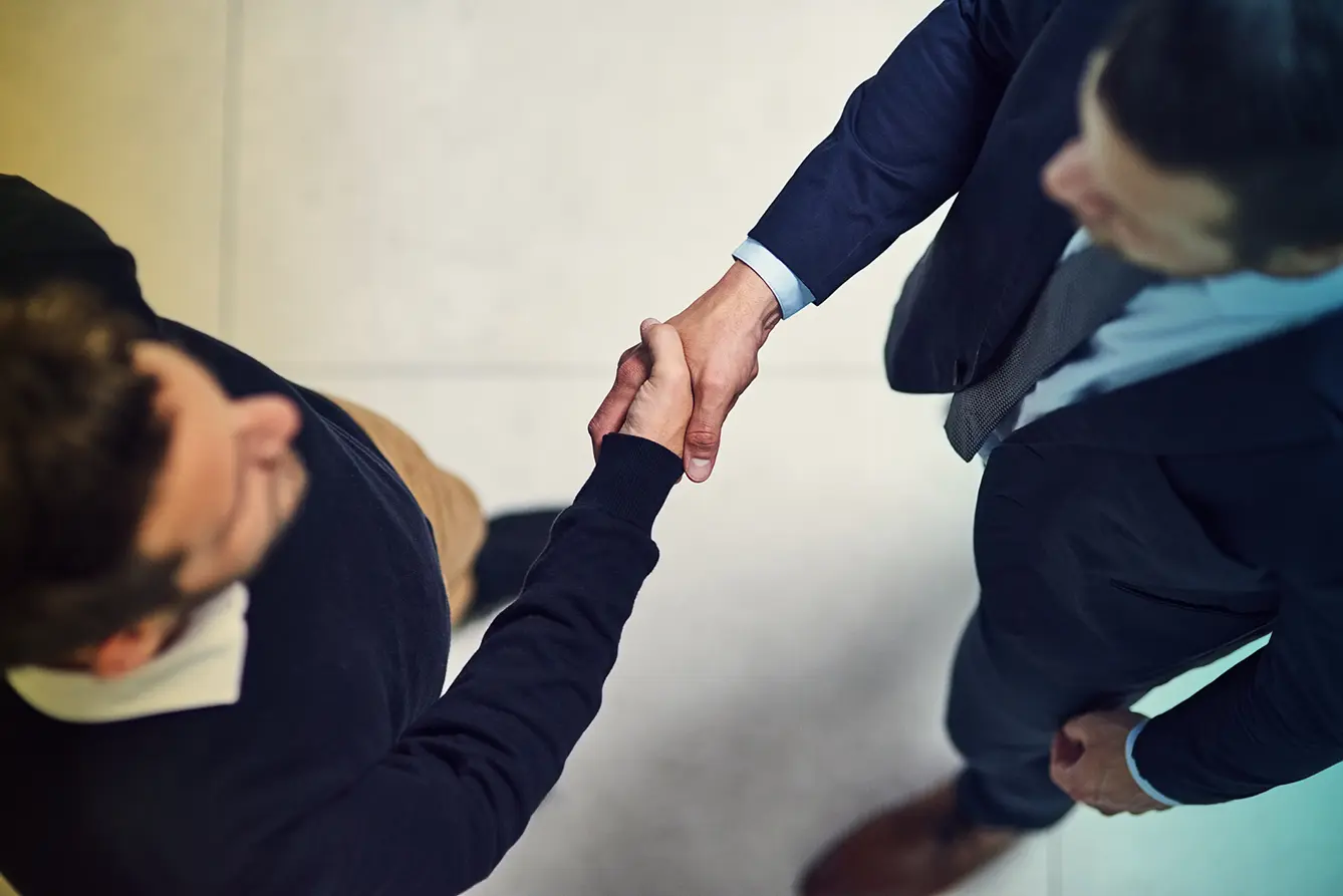 High angle shot of two businessmen shaking hands in an office