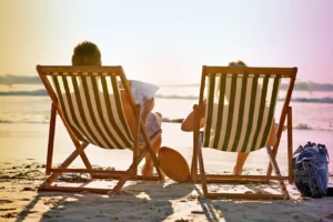 A shot taken from behind of a couple seated on beach chairs
