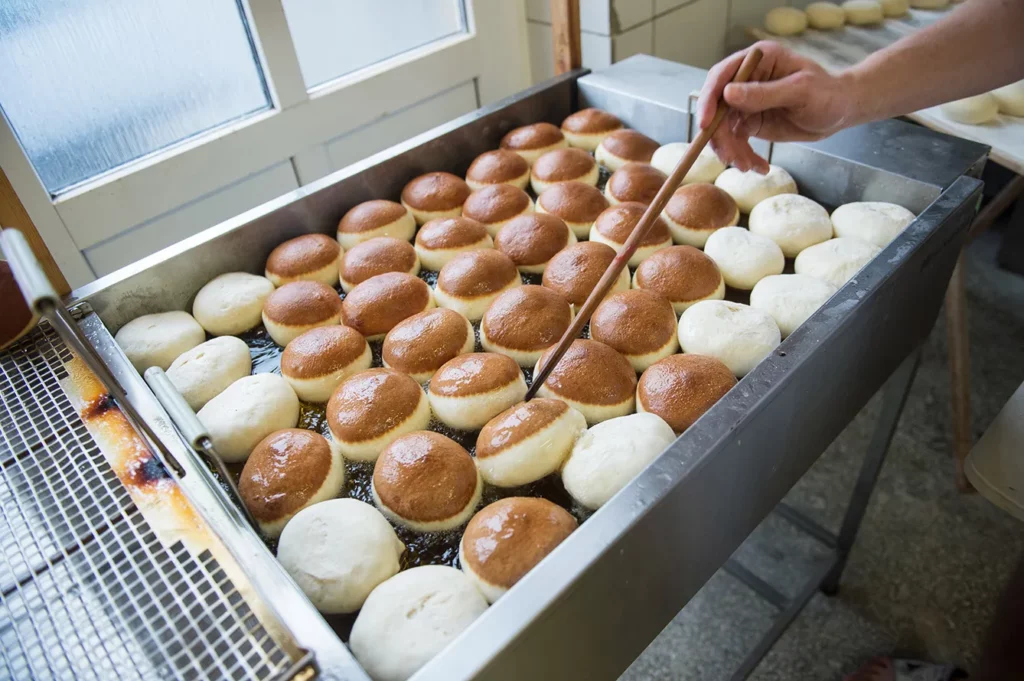 fat thursday - production of doughnuts in a bakery