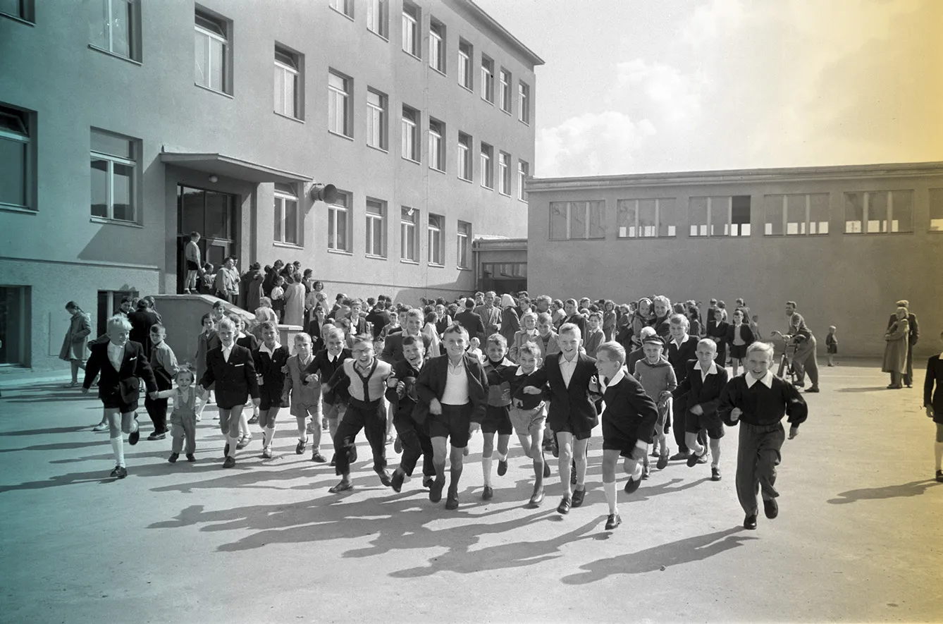 archive photo from 1959 shows students running out of school