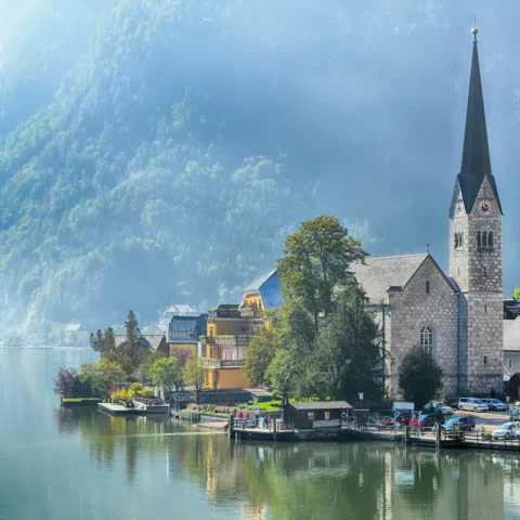 Lake view of Hallstatt village and famous church at summer season in Salzkammergut, Austria