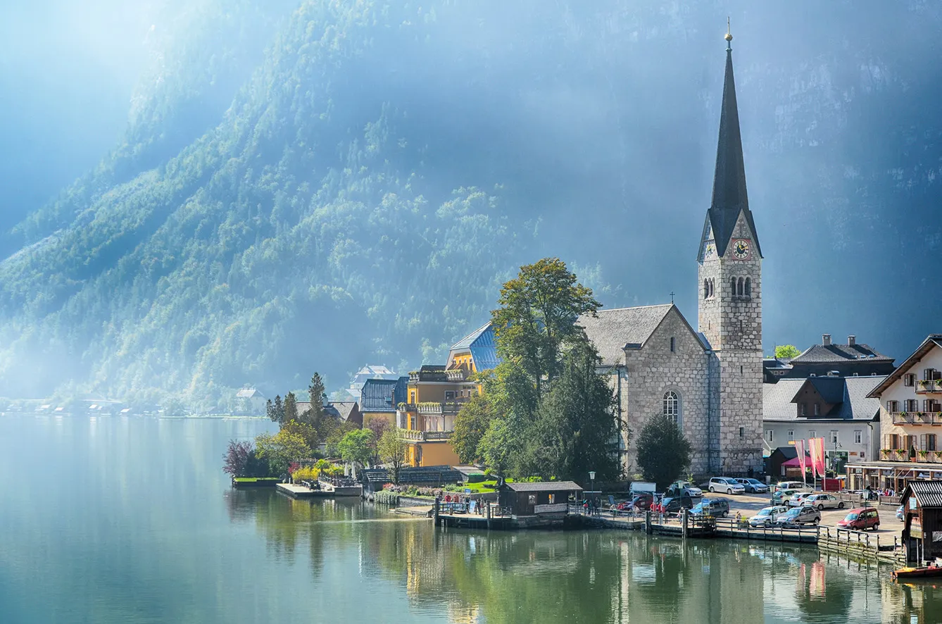 Lake view of Hallstatt village and famous church at summer season in Salzkammergut, Austria