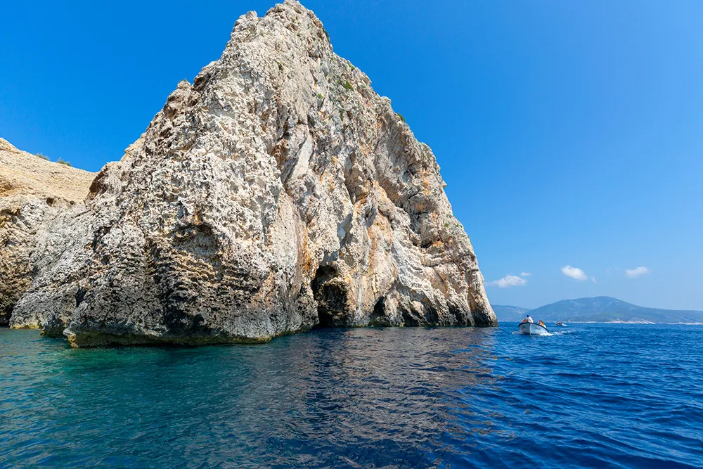 Bisevo Island, Croatia. Blue Cave carved in the limestone by the Adriatic Sea, tourists sailing by boat to the entrance