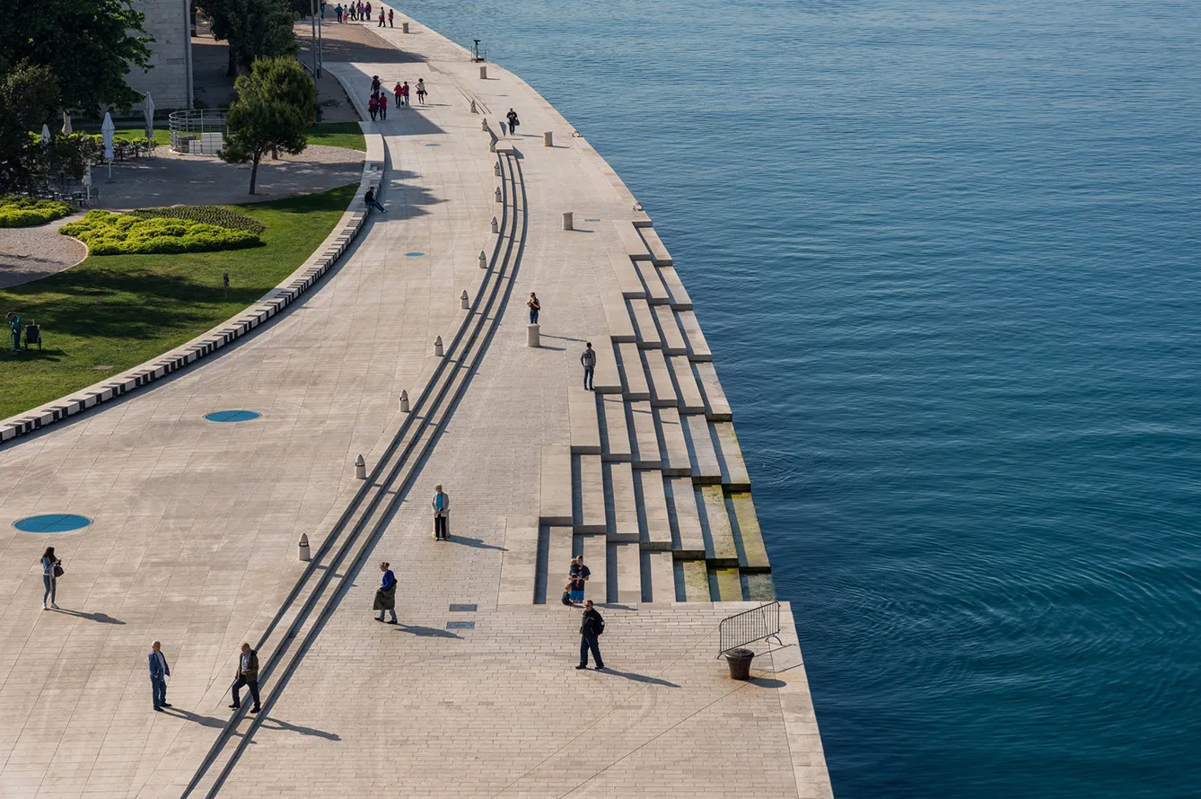 Zadar, Croatia in May: Local people on the steps of Sea Organ along the promenande by the port of Zadar in Croatia