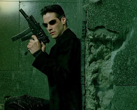 Keanu Reeves as Neo in a scene from the Warner Bros film: The Matrix (1999). Neo takes cover while armed with his Skorpions. Plot: A computer hacker learns from mysterious rebels about the true nature of his reality and his role in the war against its controllers