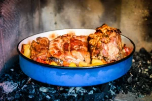 Preparing and cooking pork roast in traditional metal pot Peka. Meat and vegetables in traditional Croatian, Mediterranean meal Peka in metal pots called sach, sache - a metal lid covered with hot coals