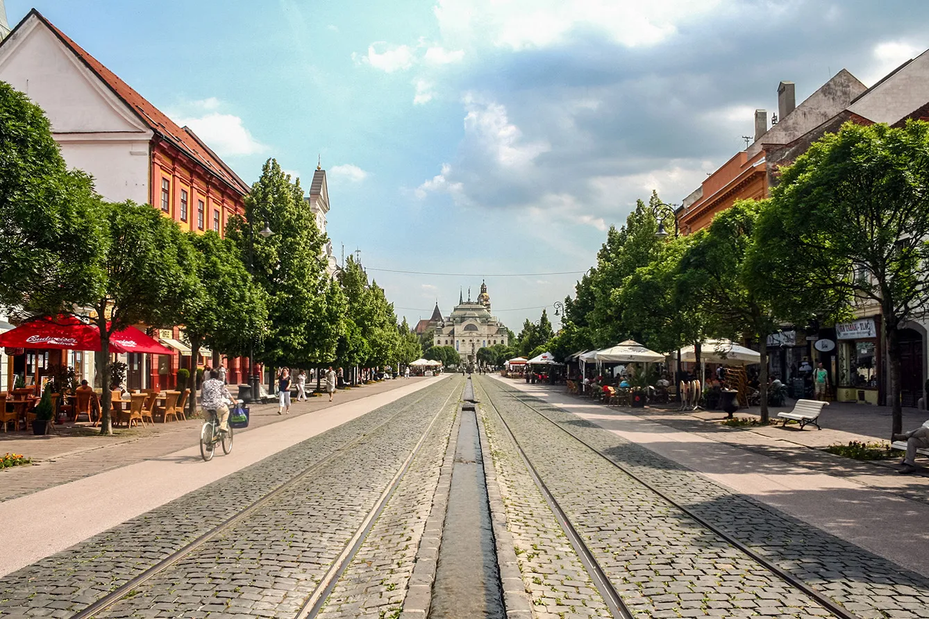 Picture of Hlavna street in Kosice, eastern Slovakia. The city of Kosice is one of the biggest of the country after Bratislava, and a cultural centre in the region. osice Main Street with pedestrians and bicycles passing by. The national theatre Divadlo can be seen in the background