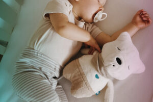 baby sleeps with a teddy bear