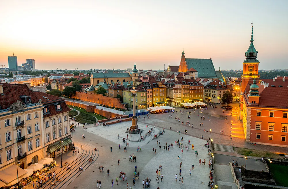 Top view of Royal castle and old town crowded with people in Warsaw on the evening