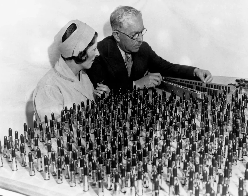 Max Factor (r) the Polish-born cosmetics magnate examines lipsticks with Ray Judd at his factory in Hollywood, California, 1932.