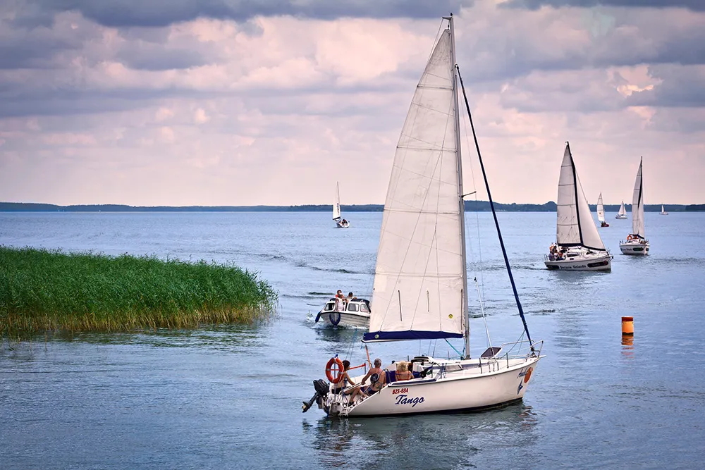 Mikołajki, Poland. Adult people sailing yachts on the lake Śniardwy, the bigest lake in Poland in Masurian Lake District