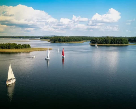 Aerial view of green islands and clouds at summer sunny day. Masurian Lake District in Poland
