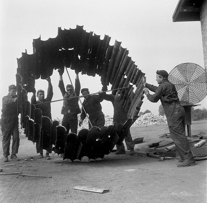 Elblag, 1965, working on a sculpture by Krystyn Zielinski. This realization was created by joining the edges of pipes cut lengthwise into a circle. Viewed from a lateral perspective, it gives the impression that it was not made of metal - that the material of this sculpture is organic matter, such as tree bark. It is located on Giermków Street